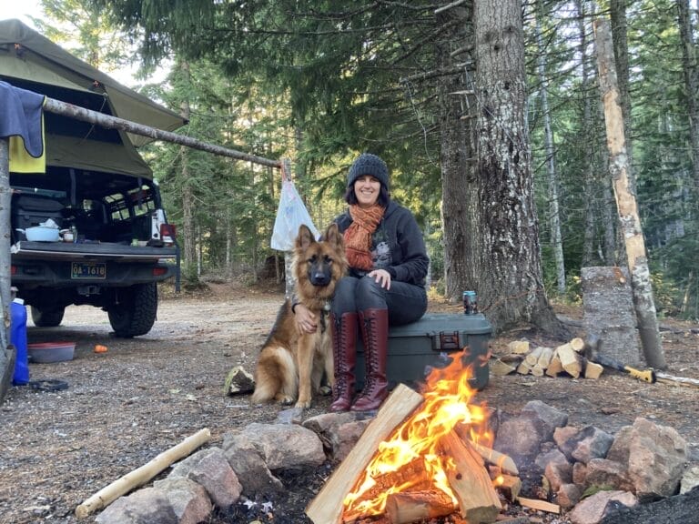 Woman solo camping with a German shepherd dog.