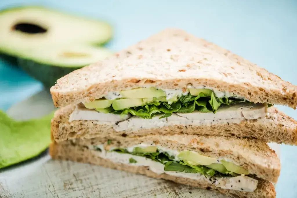 Healthy sandwich with avocado and chicken and salad.