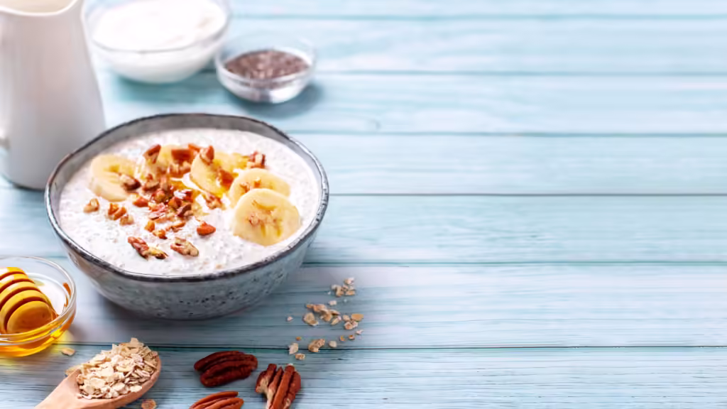 Banana and pecan nuts overnight oatmeal with chia seeds in bowl, rich in protein breakfast or snack