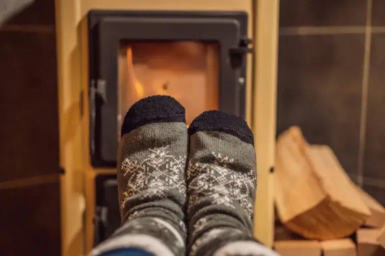 Cozy socks warming feet by the fire in a glamping tent.