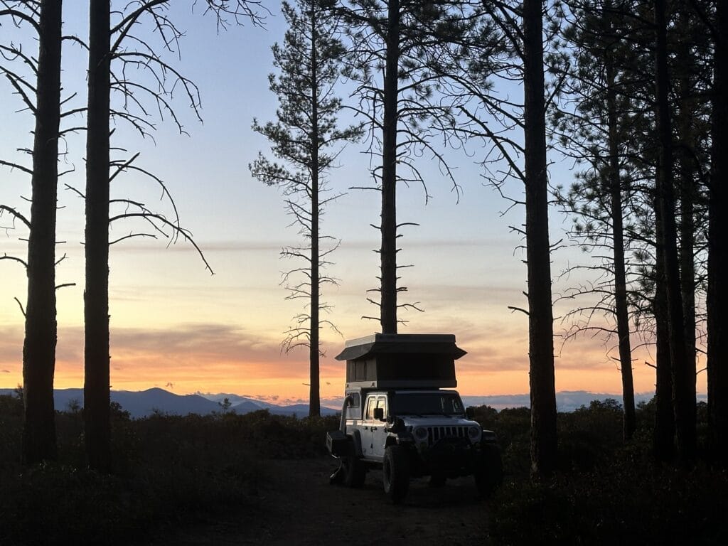 Jeep Gladiator at camp with a beautiful sunset in the background.