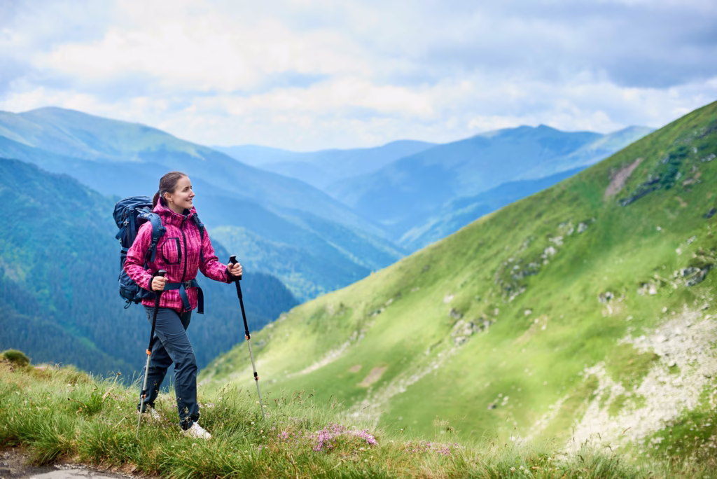 Woman on a solo hike in the mountains wearing a pink jacket.