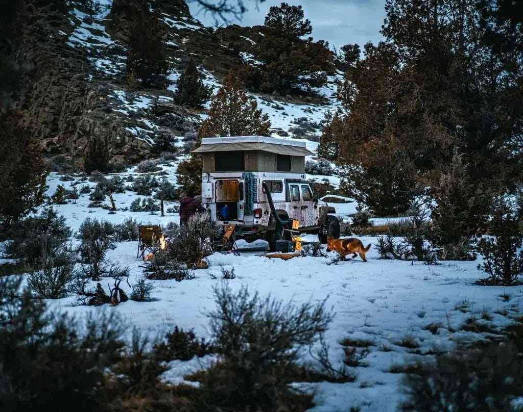 Jeep gladiator with rooftop tent camping in the snow.
