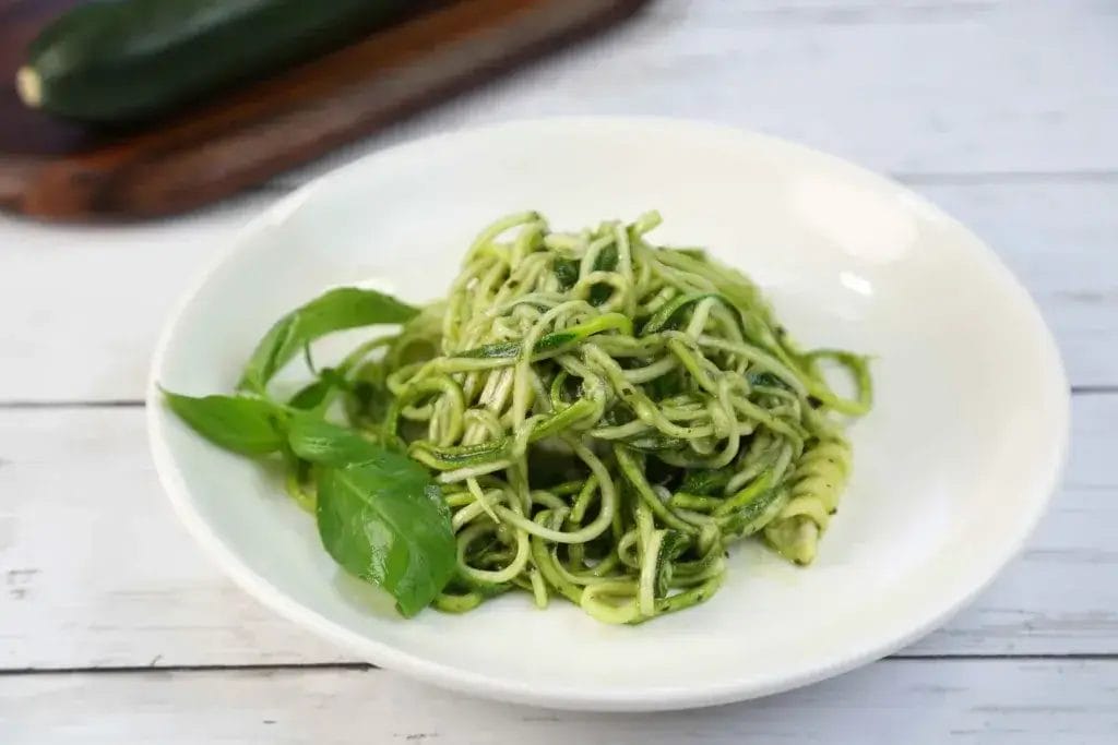 Zucchini pesto salad on a white plate.