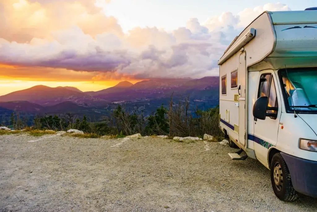 RV parked at an overlook at sunset.