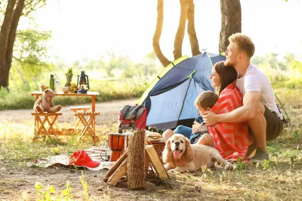 Couple, young child and a dog camping.