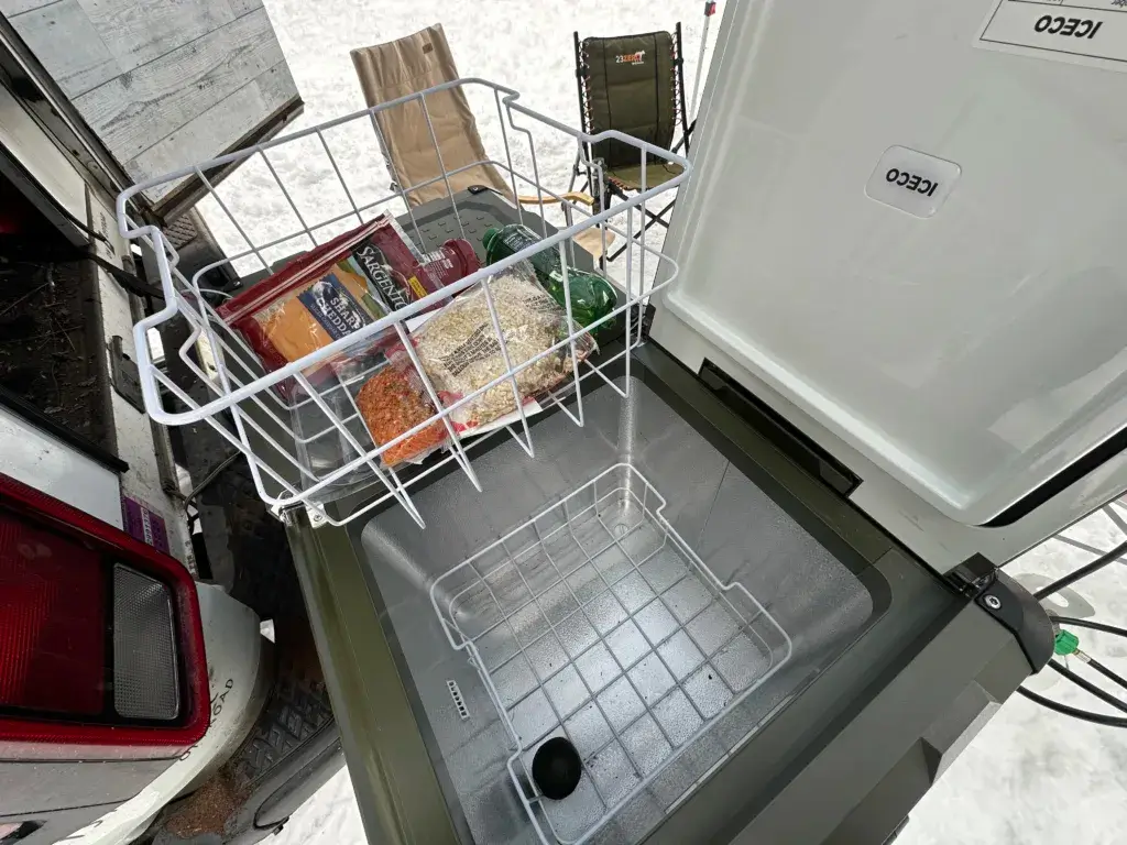 Iceco refrigerator with one side open and a basket full of food.