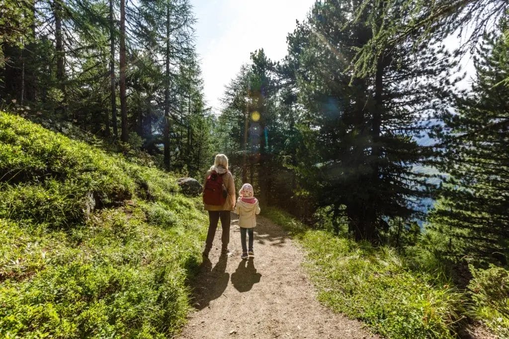 Young mother and child on a scavenger hunt hike in the forest.