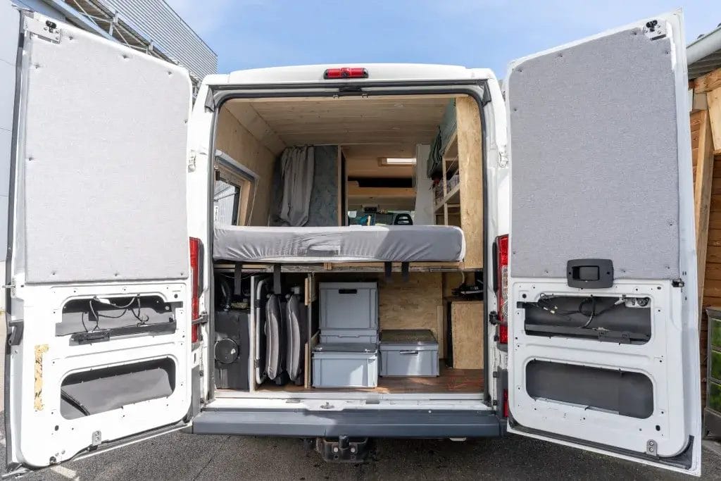 Trunk of camper van with storage containers.