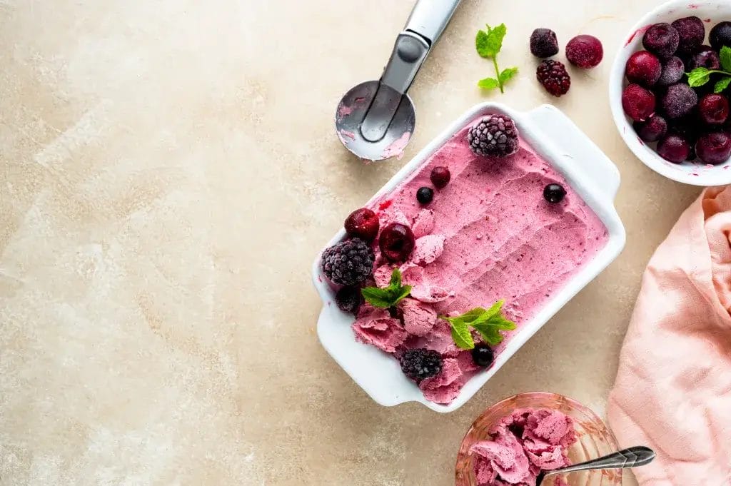 Strawberry banana slush frozen in a white glass container.
