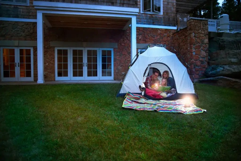 Family in a tent in the backyard.