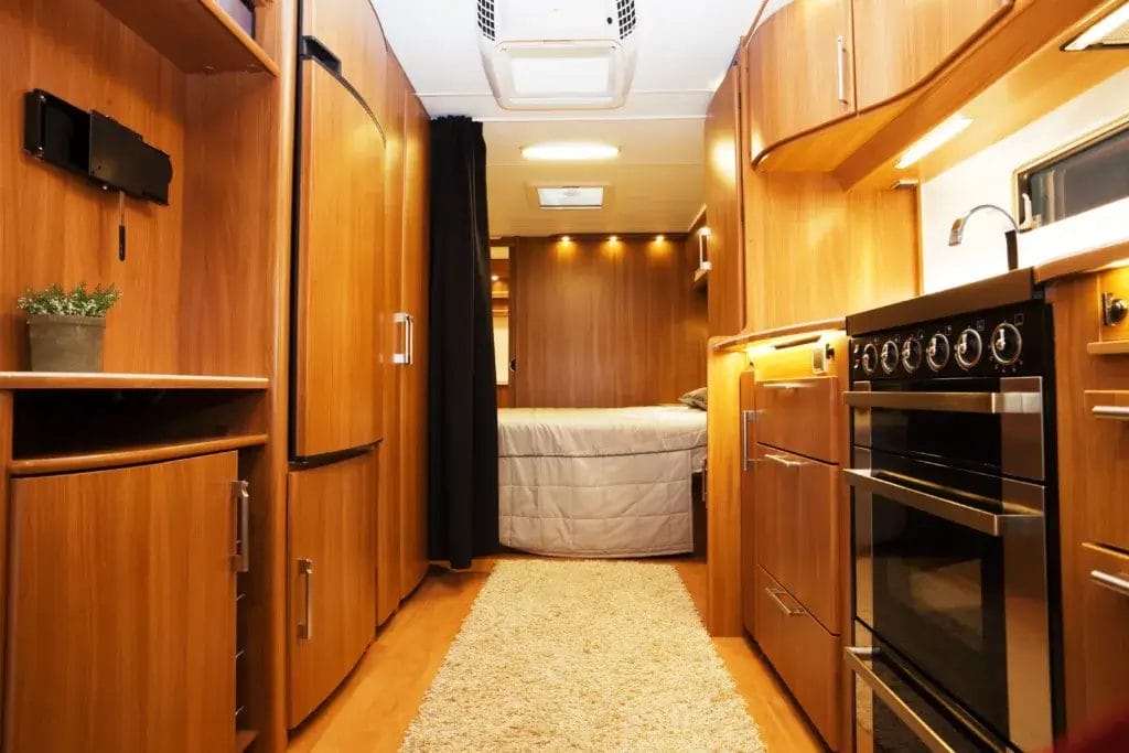 RV interior with wood flooring and a rug to protect the floor.