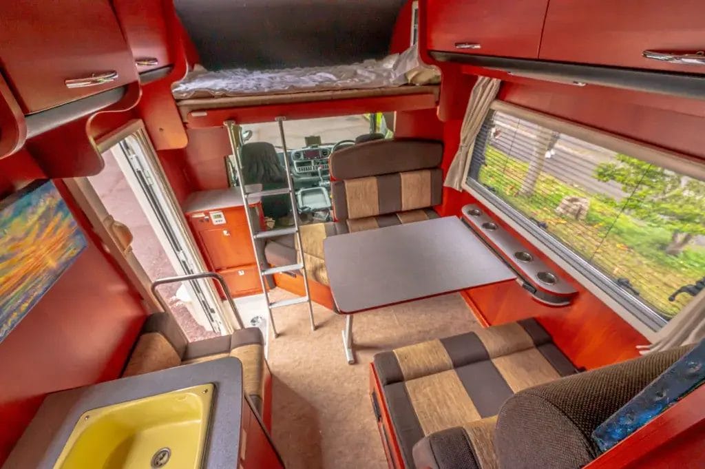 Interior of a camper van with colorful orange walls.