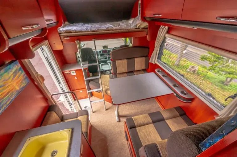 Interior of a camper van with colorful orange walls.