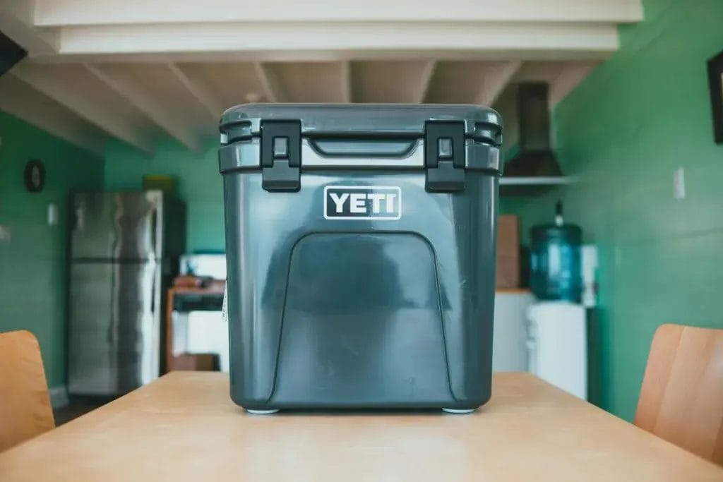 Sturdy YETI cooler placed on a wooden table in a cozy cabin-themed kitchen interior.